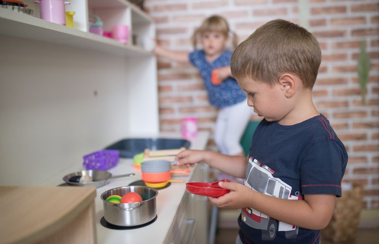 Chlapec vaří oběd v dětské kuchyňce