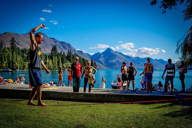 Trénování slackline u jezera nad měkkým povrchem